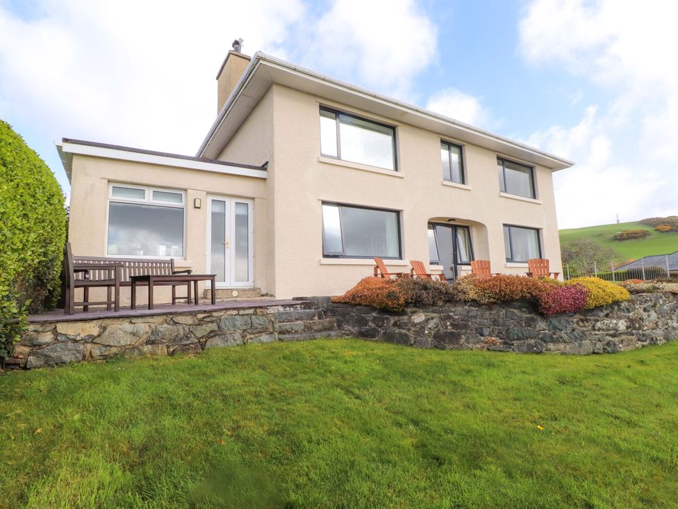 A house with a patio and furniture at Bryn Deryn in Criccieth