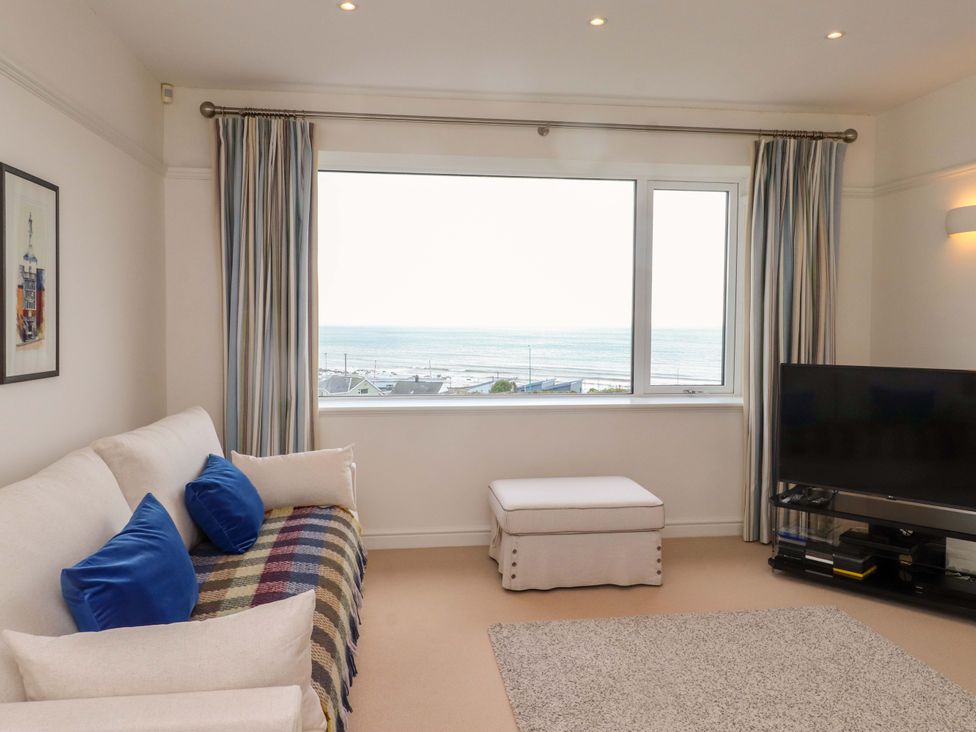 A living room with a sofa and TV at Bryn Deryn in Criccieth