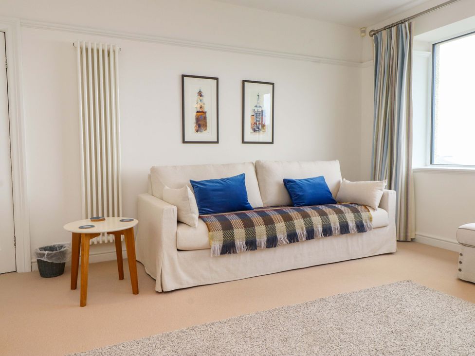 A living room with a sofa and coffee table at Bryn Deryn in Criccieth