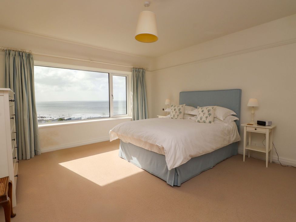 A bedroom with a bed and sea view at Bryn Deryn Criccieth