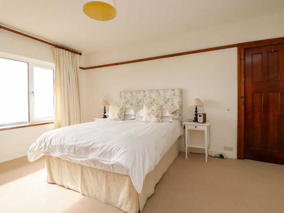 A bedroom with a bed and curtains at Bryn Deryn in Criccieth