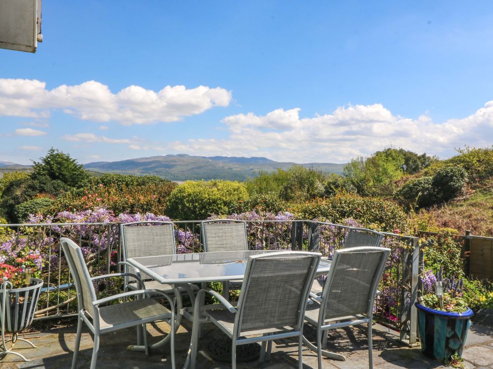 A seating area with a table and chairs overlooking a landscape at Bryn Y Mor, Borth Y Gest