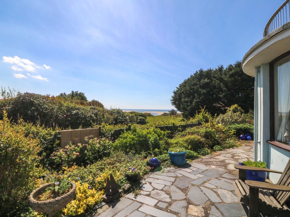 A garden view with plants and seating area at Bryn Y Mor, Borth Y Gest