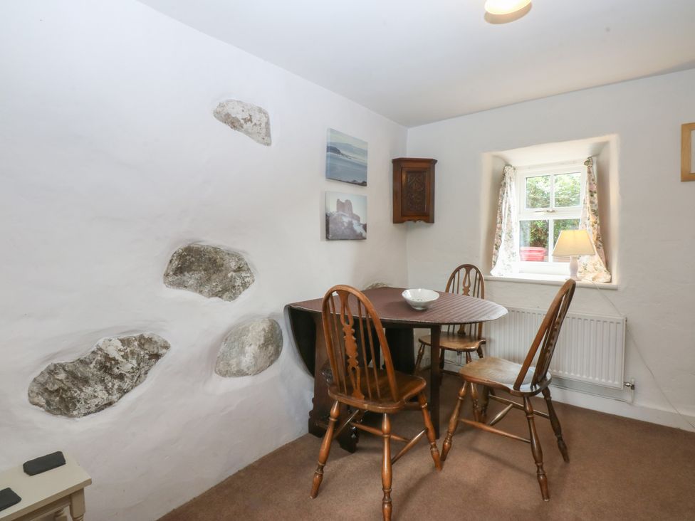 A dining room with a table and chairs at Y Bwthyn Criccieth