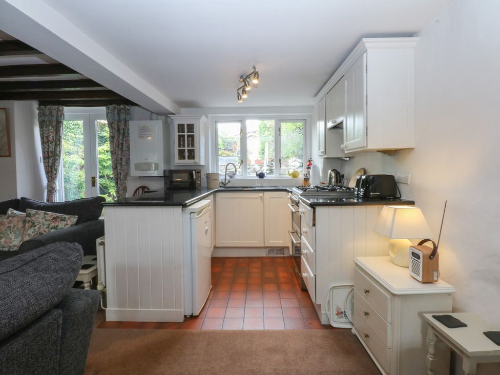 A kitchen with countertop, sink, stove at Y Bwthyn in Criccieth