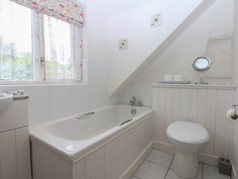 A bathroom with a bathtub and toilet at Y Bwthyn Criccieth