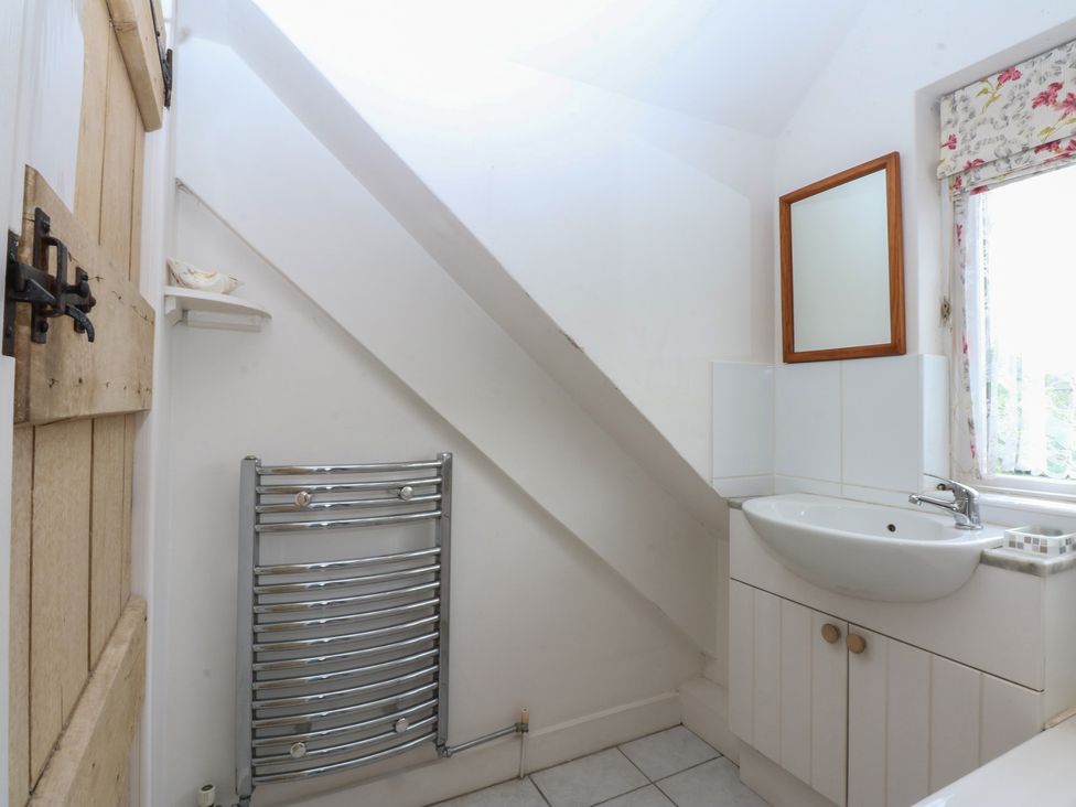 A bathroom with a sink and towel radiator at Y Bwthyn in Criccieth