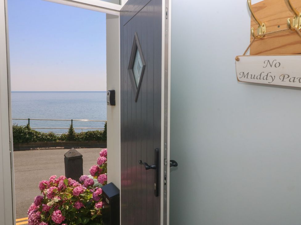 An entryway with a view of the ocean and flowers outside at Captain's Rest in Criccieth