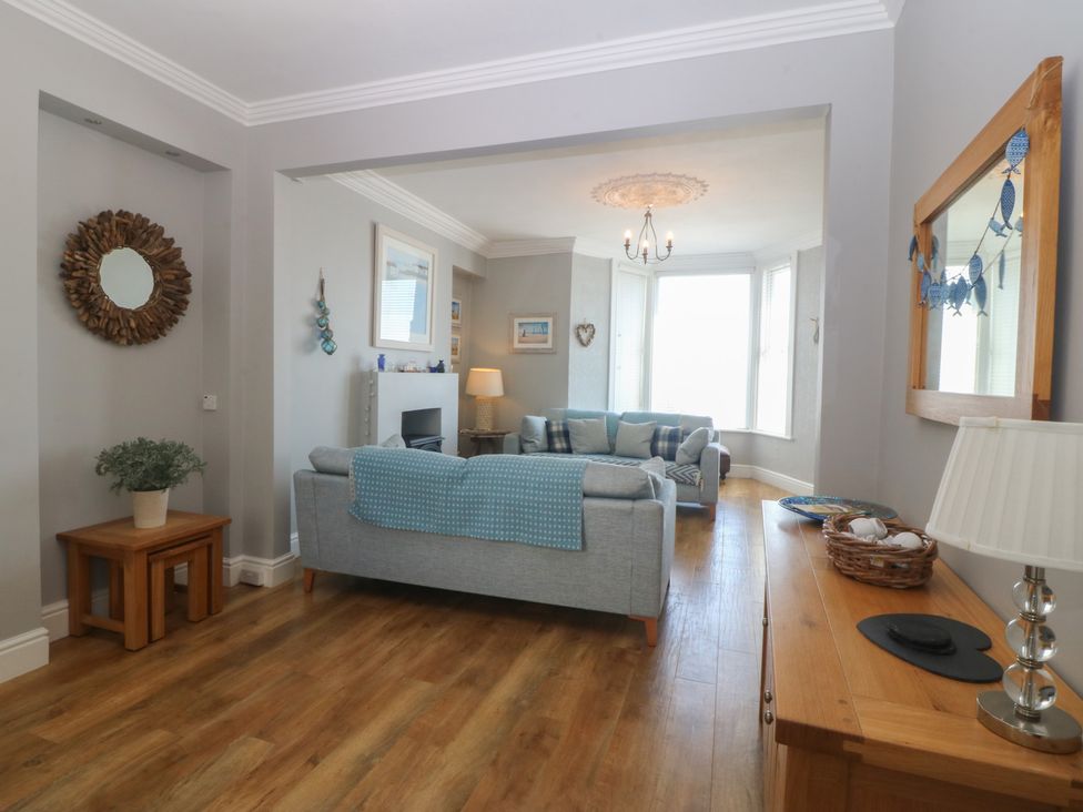 A living room with a sofa and table at Captain's Rest in Criccieth