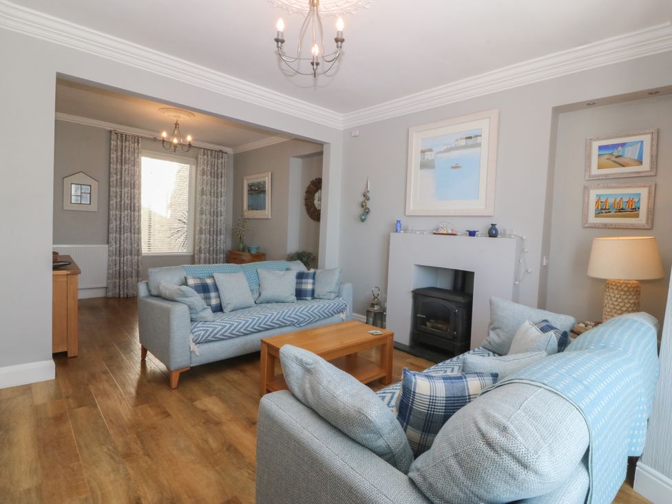 A living room with sofas and a coffee table at Captain's Rest in Criccieth