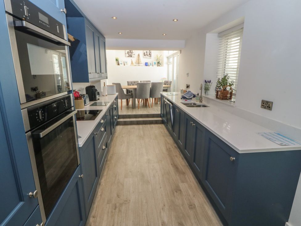A kitchen with cabinets and appliances at Captain's Rest in Criccieth