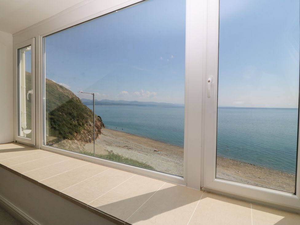 A view of the sea and beach from a window at Captain's Rest in Criccieth