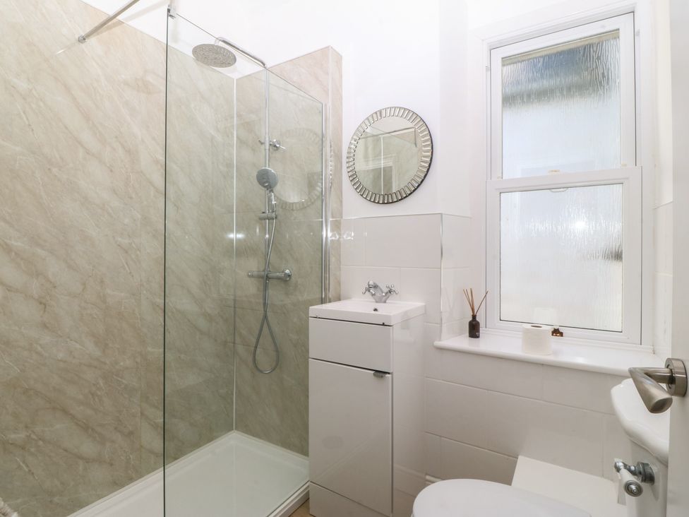 A bathroom with a shower, sink and toilet at Captain's Rest in Criccieth