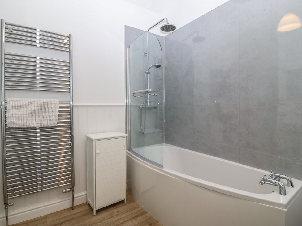 A bathroom with a bathtub and shower at Captain's Rest in Criccieth