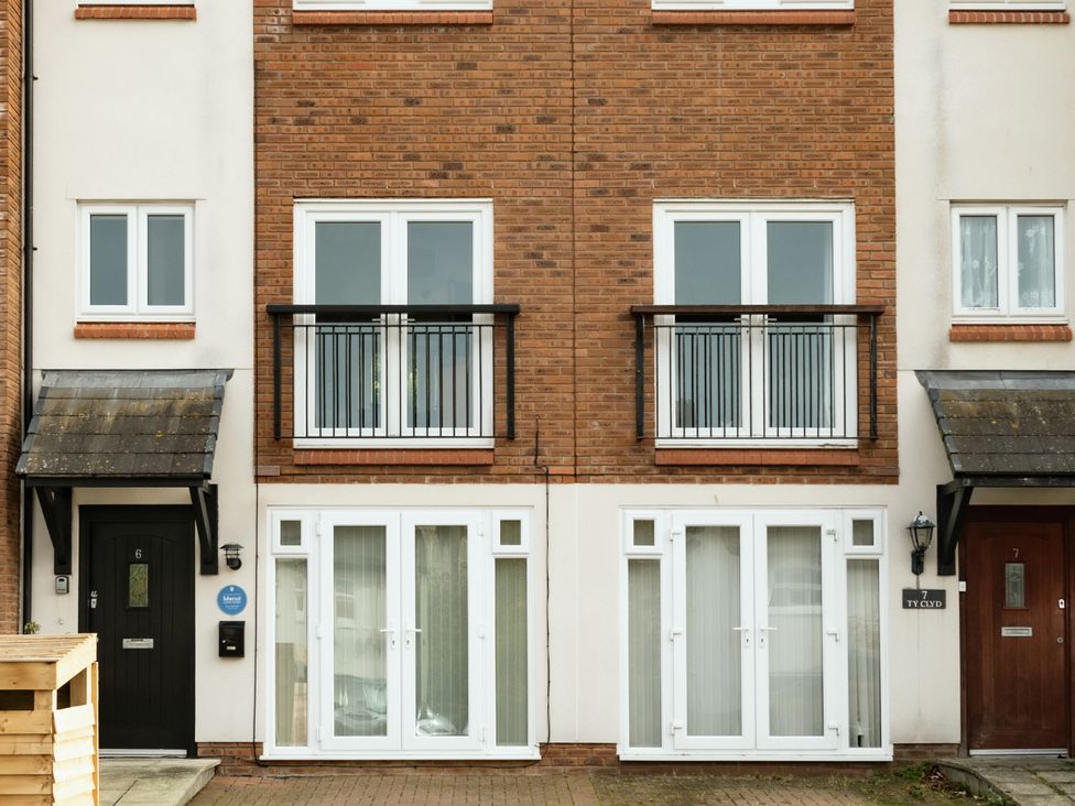 A building facade with balconies and doors at Coed y Felin in Conwy