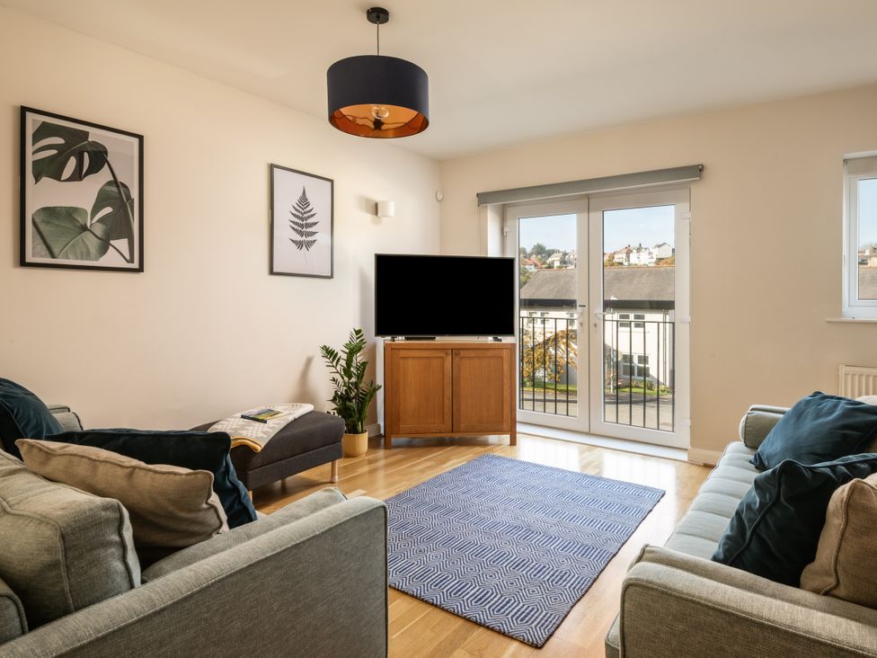 A living room with a television and sofa at Coed y Felin in Conwy