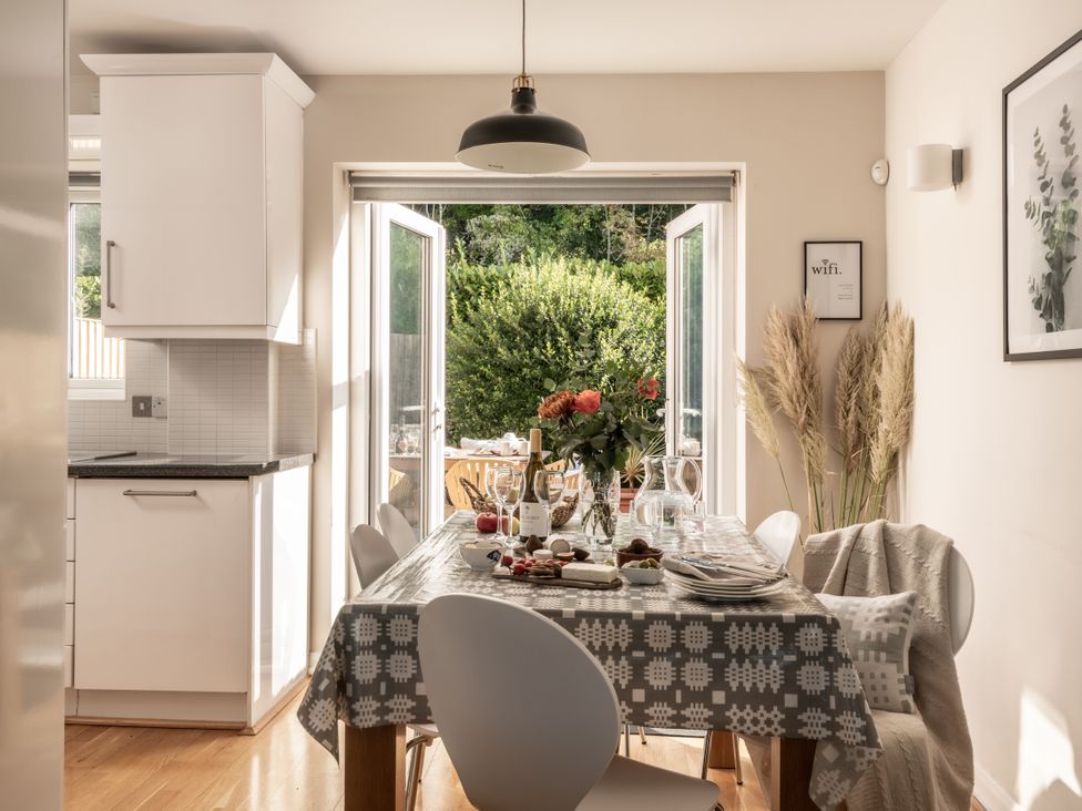 A dining room with a table set for meals at Coed y Felin in Conwy