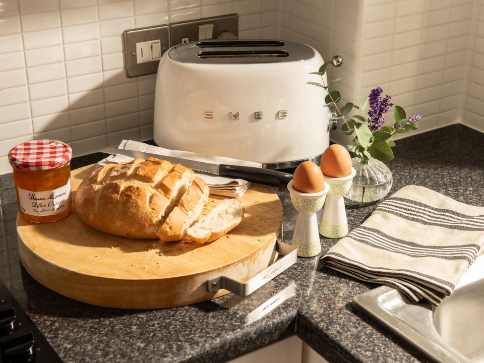 A kitchen with bread, eggs, a toaster, and jam at Coed y Felin in Conwy