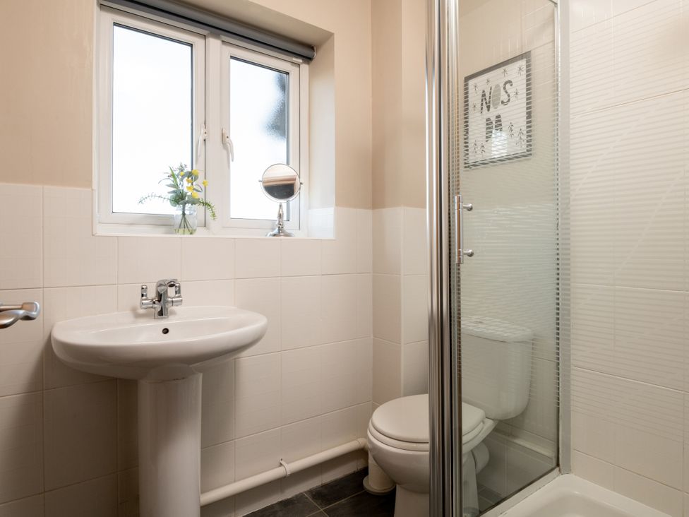 A bathroom with a sink, toilet, and shower at Coed y Felin in Conwy