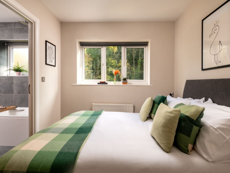 A bedroom with a bed and window at Coed y Felin in Conwy