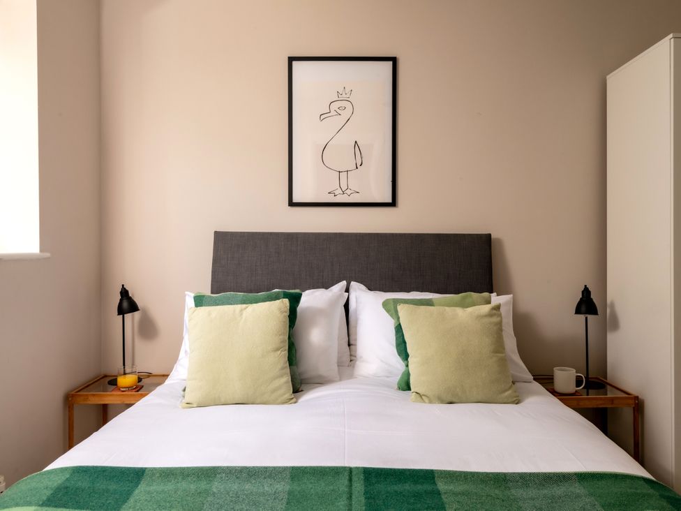 A bedroom with a bed and artwork at Coed y Felin in Conwy