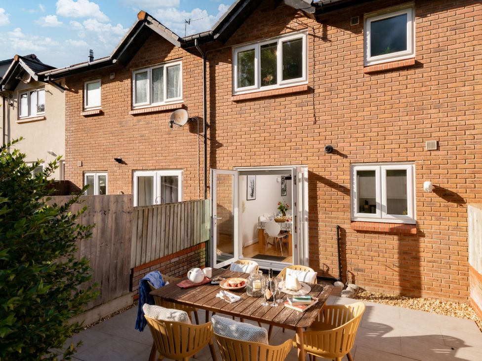 A garden with a table and chairs at Coed y Felin in Conwy