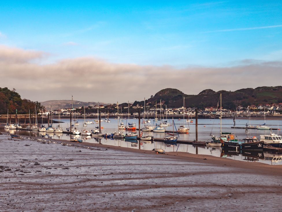 A marina with boats on the water and hills in the background at Coed y Felin Conwy