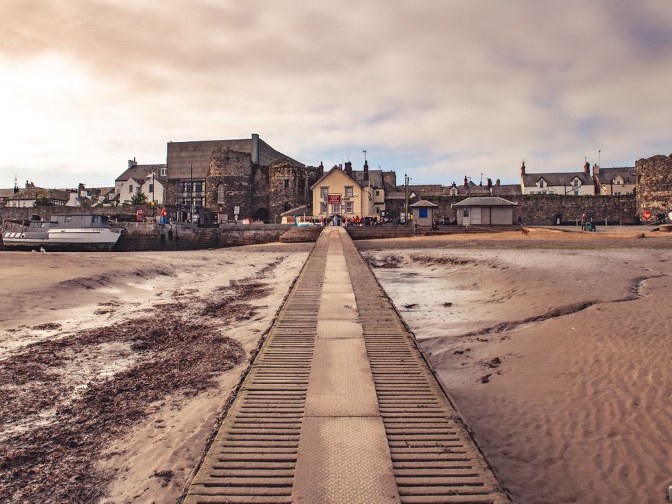 A pier leading to buildings and boats at Coed y Felin in Conwy