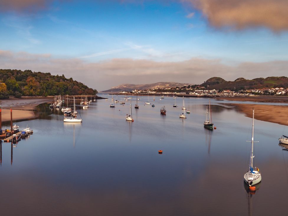 A view of boats on a river with hills in the background at Coed y Felin, Conwy