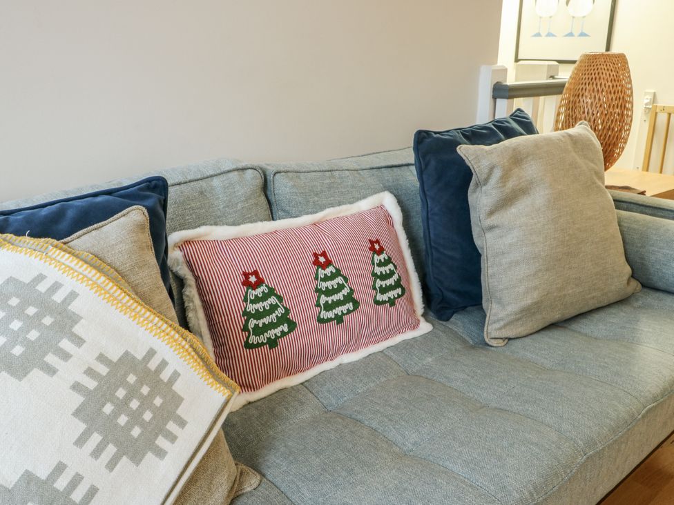 A sofa with cushions and decorative pillows at Coed y Felin in Conwy