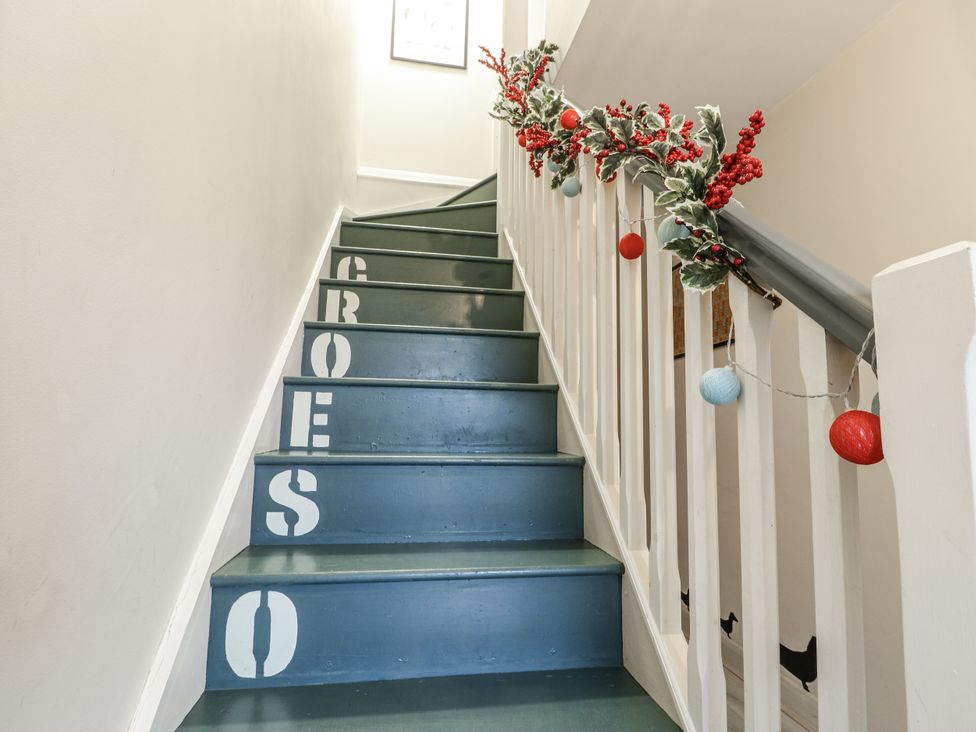 A staircase with decorative garland at Coed y Felin in Conwy