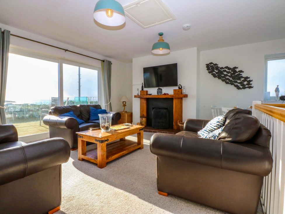 A living room with a coffee table and television at Curragho in Trearddur Bay