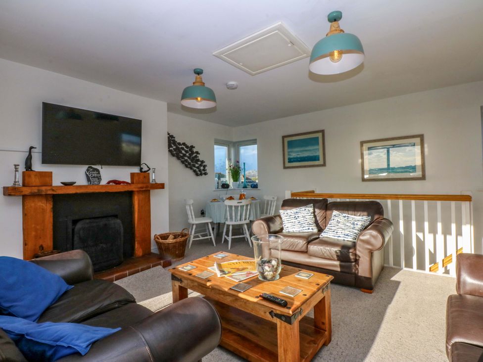 A living room with a television and fireplace at Curragho in Trearddur Bay