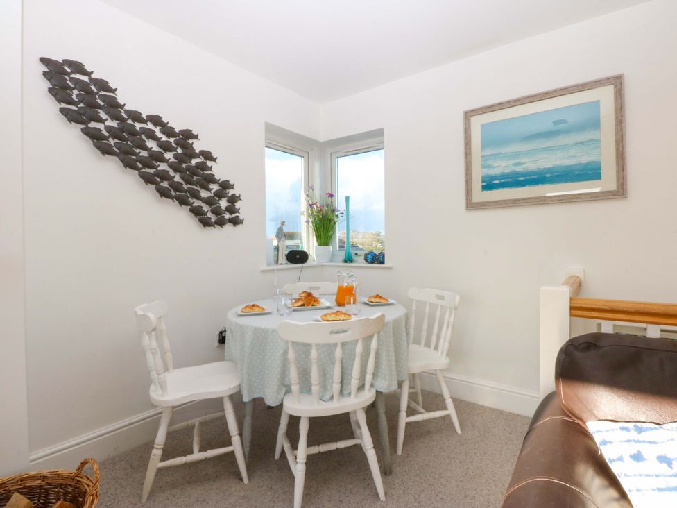A dining room with a table and chairs at Curragho in Trearddur Bay