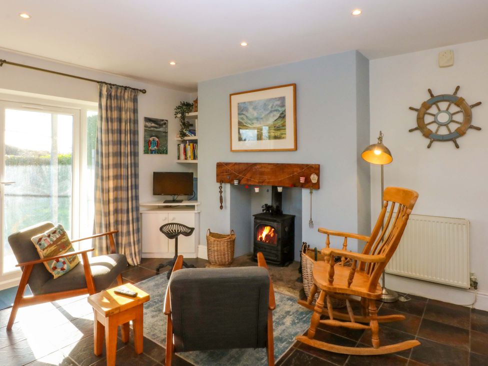 A living room with a fireplace and furniture at Curragho in Trearddur Bay