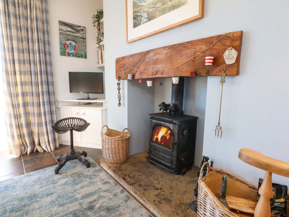 A snug with a fireplace and television at Curragho in Trearddur Bay