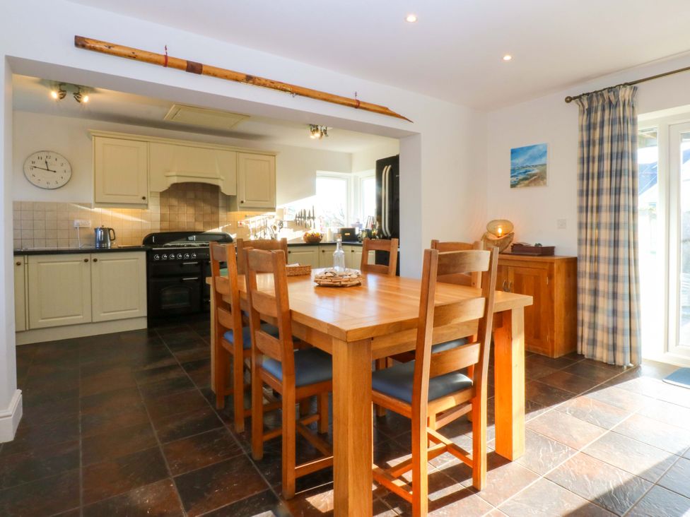 A kitchen with a dining table and chairs at Curragho in Trearddur Bay