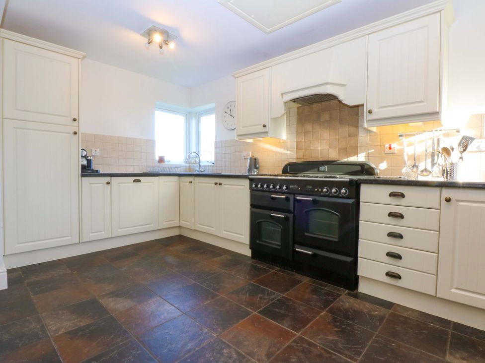 A kitchen with cabinets and an oven at Curragho in Trearddur Bay