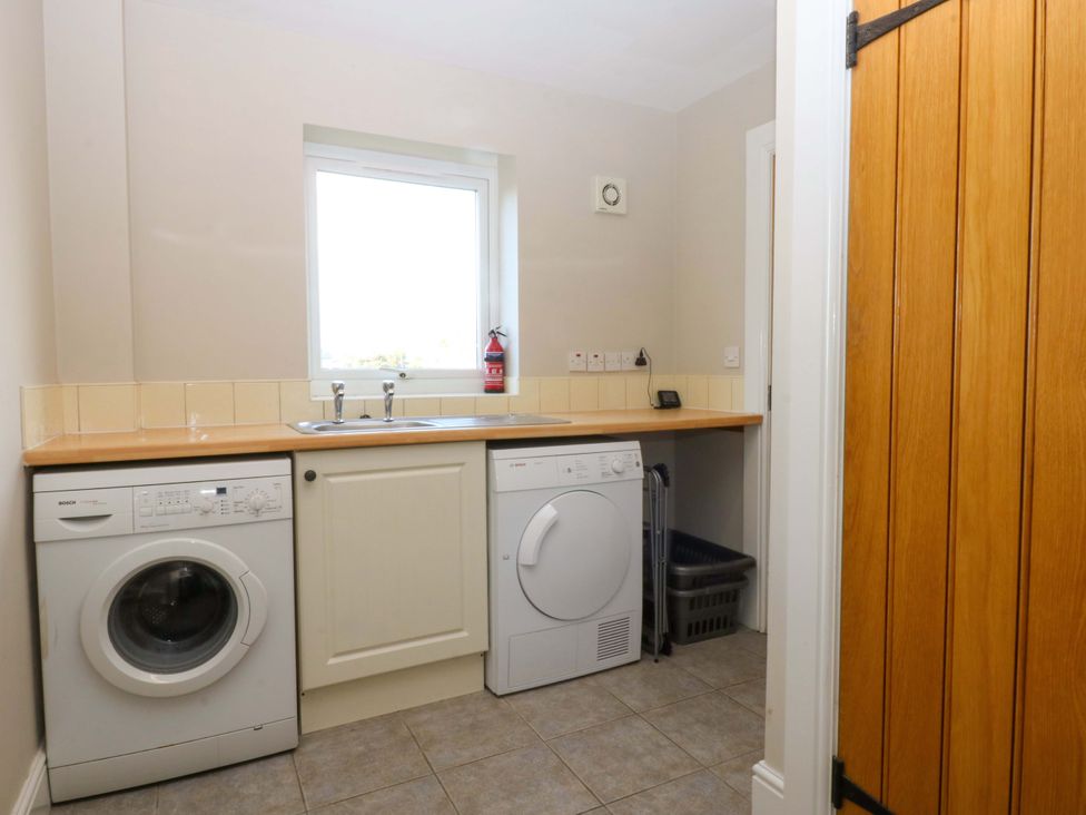 A laundry room with a washing machine and dryer at Curragho in Trearddur Bay