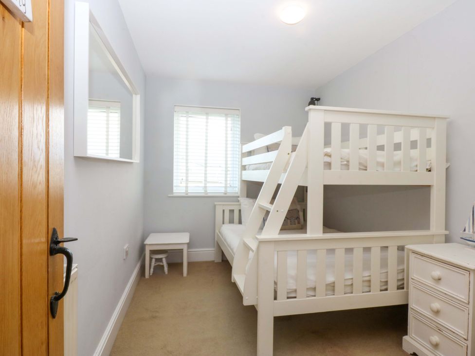 A bedroom with a bunk bed and a single bed at Curragho in Trearddur Bay