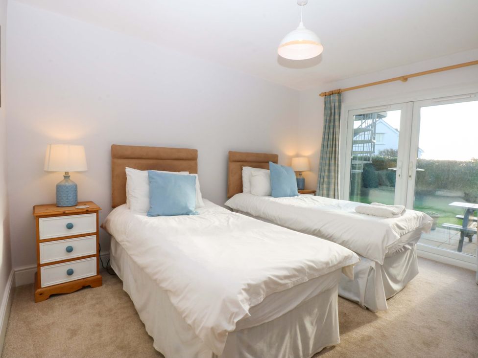 A bedroom with two single beds and a nightstand at Curragho in Trearddur Bay