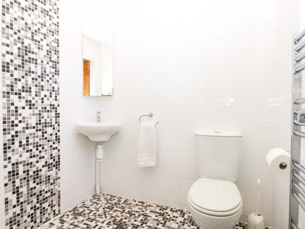 A bathroom with a toilet and hand basin at Curragho in Trearddur Bay