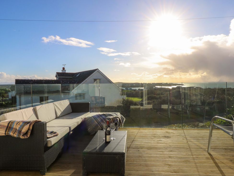 An outdoor seating area with sofa and coffee table at Curragho in Trearddur Bay