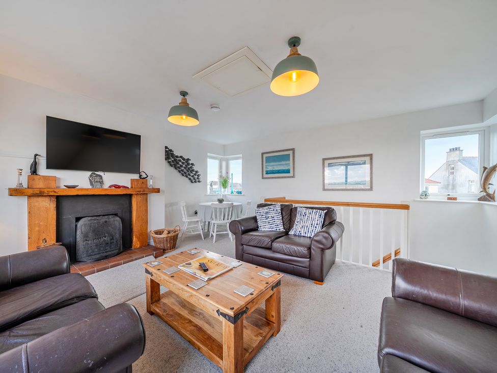 A living room with a television and seating area at Curragho in Trearddur Bay