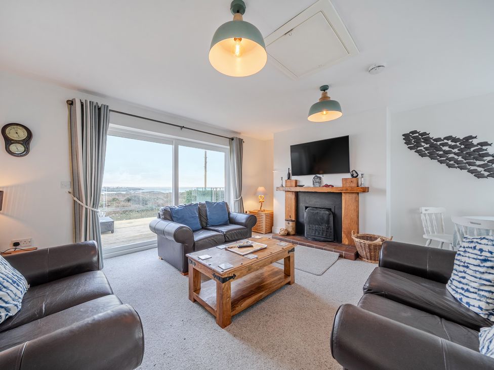 A living room with a sofa and television at Curragho in Trearddur Bay