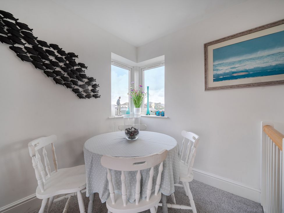 A dining room with a table and chairs at Curragho in Trearddur Bay