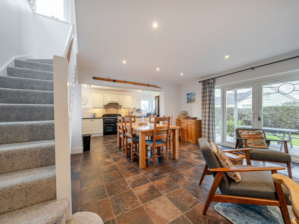 A dining room with a table and chairs at Curragho in Trearddur Bay