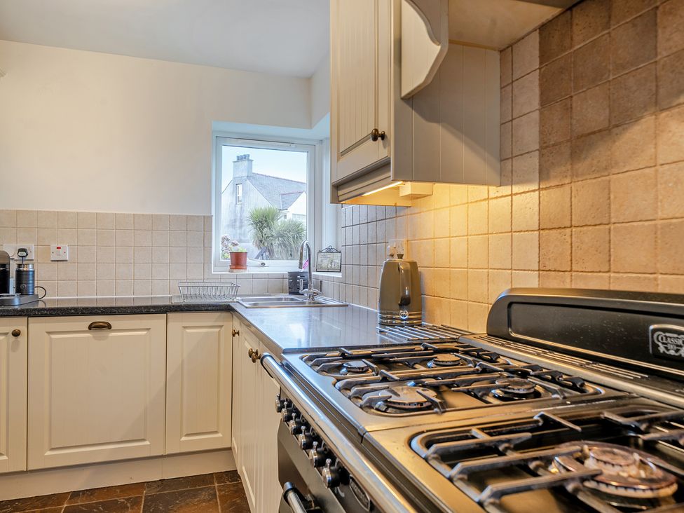 A kitchen with sink and stove at Curragho in Trearddur Bay