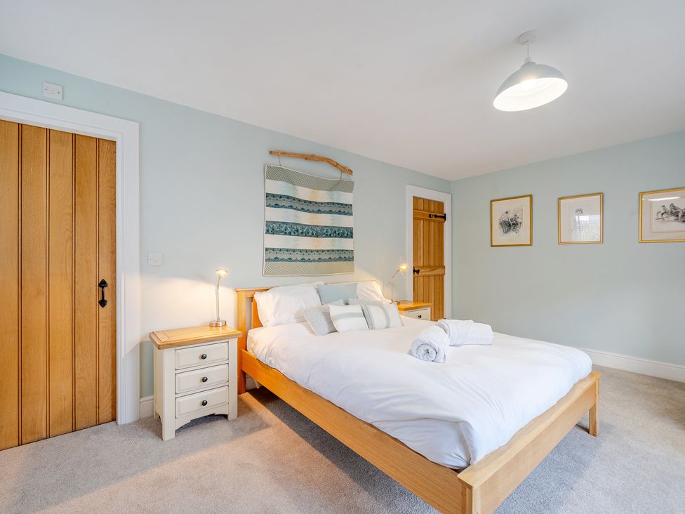 A bedroom with a bed and bedside table at Curragho in Trearddur Bay