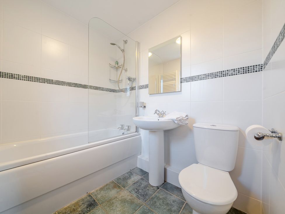 A bathroom with a bathtub a sink and a toilet at Curragho in Trearddur Bay